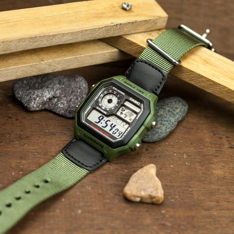 Casio AE-1200WHB-3BVDF digital watch with a rugged green nylon strap, black rectangular resin case, and a world map display on the face. Features include world time, multiple alarms, LED backlight, and 100-meter water resistance. - Zamana.pk