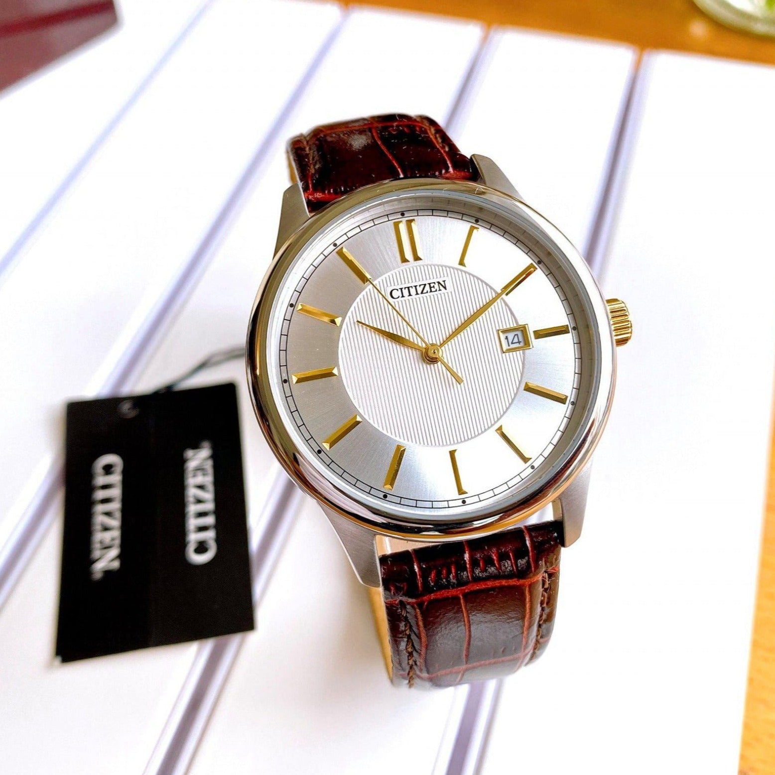 Citizen BI1054-04A men's analog watch with a white dial, silver-tone stainless steel case, brown leather strap, and date display at the 3 o'clock position. - Zamana.pk Main image